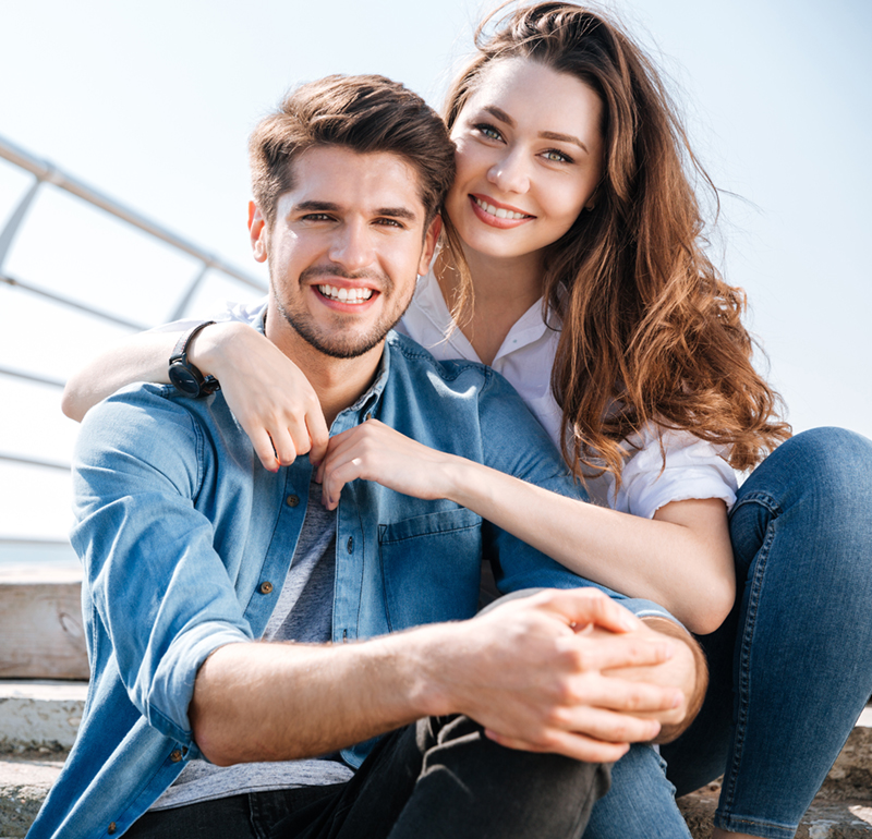 young couple hugging and smiling at camera